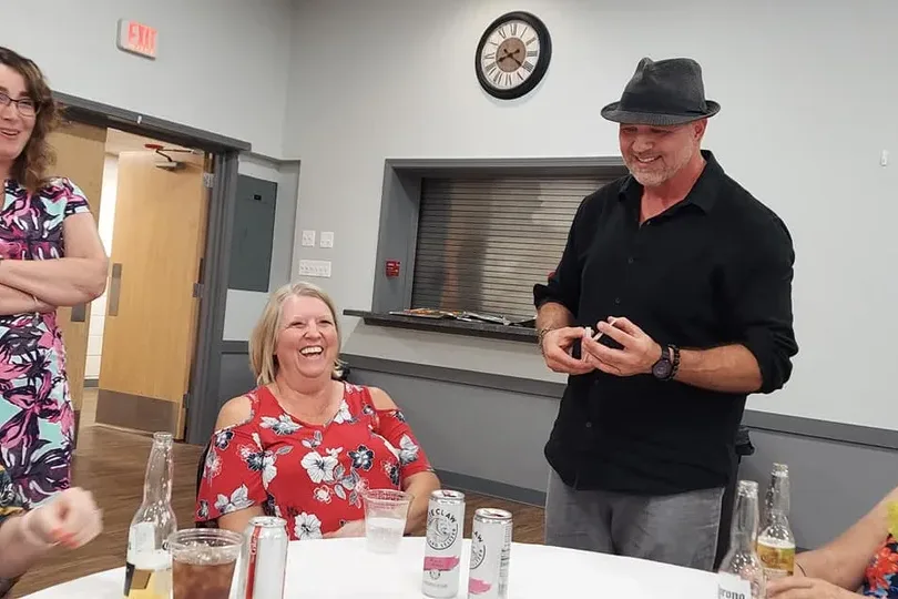 Women laughing during close-up magic at private party