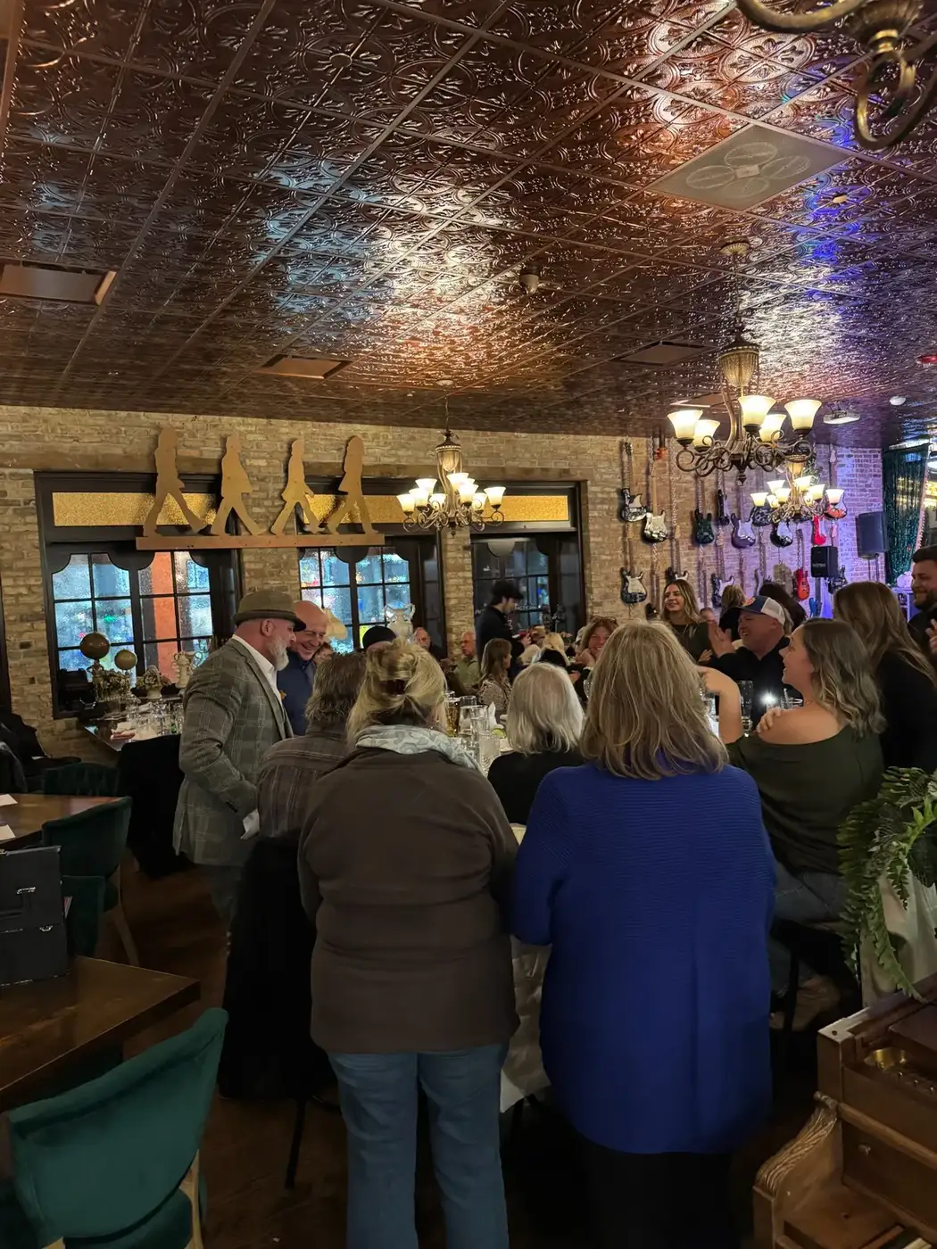 Mike DiDomenico performing table-side magic at packed Club Arcada dinner show with tin ceiling and brick walls