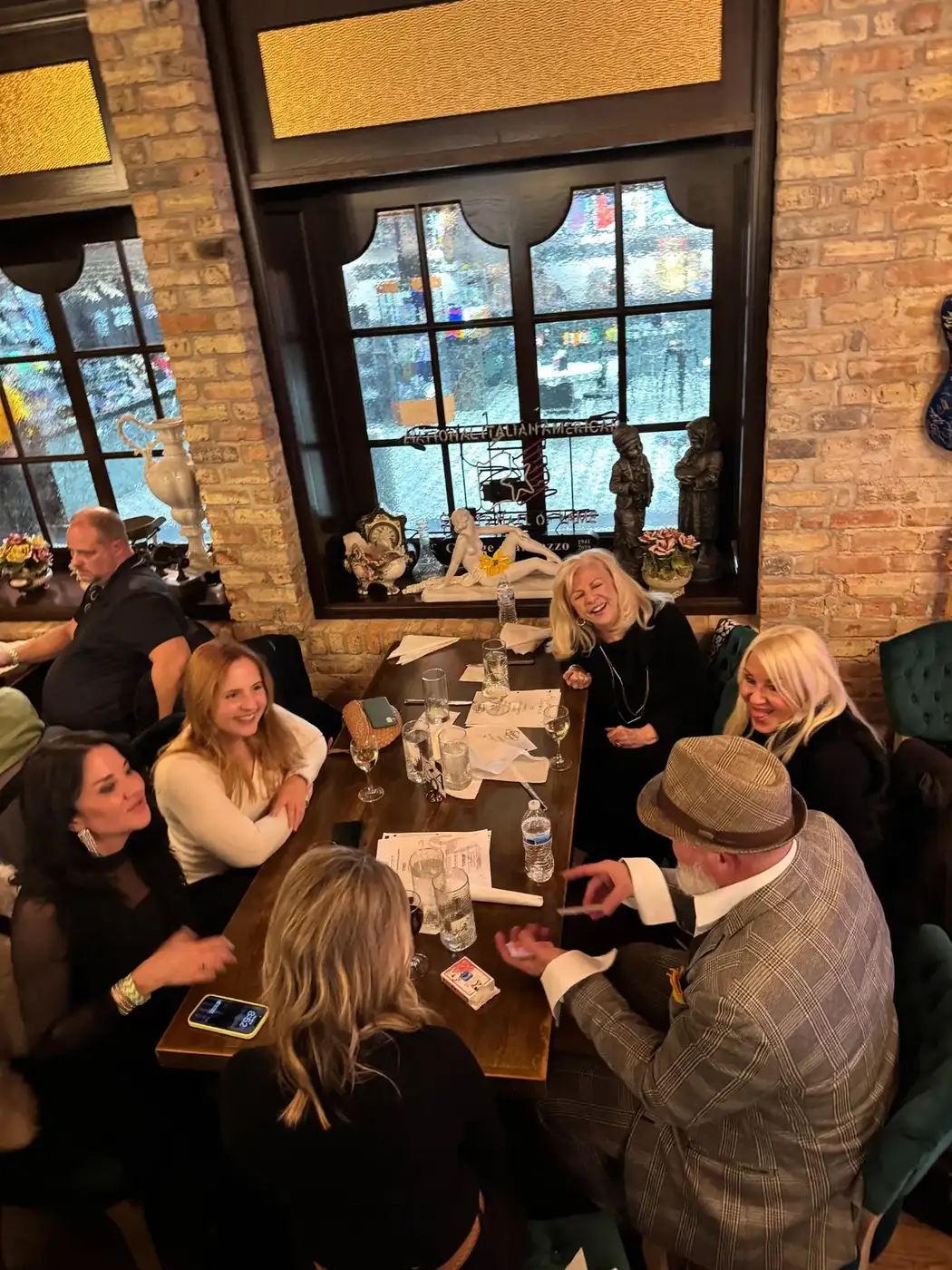 Women laughing during close-up magic performance at Club Arcada