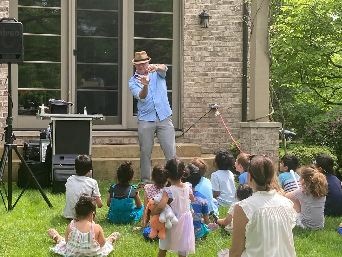 Wide shot of Mike DiDomenico performing for a backyard party audience
