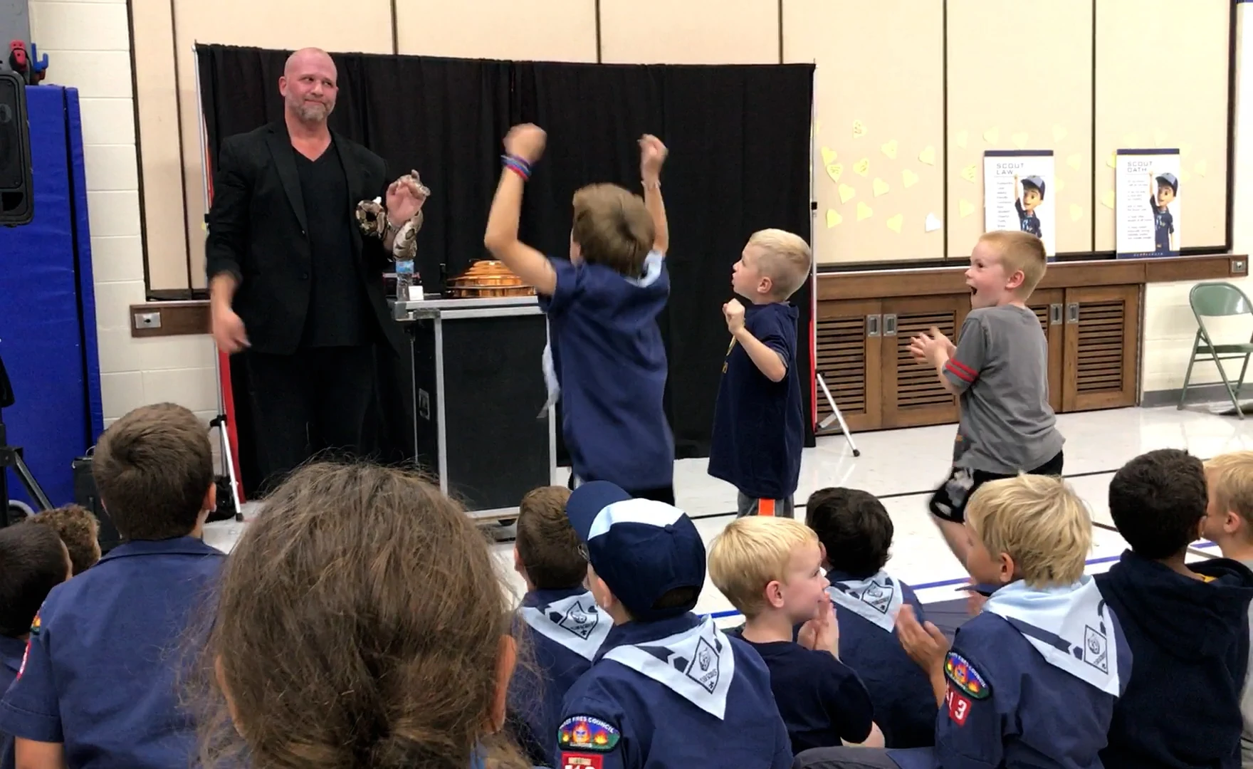 Scouts jumping out of their seats in excitement as Mike DiDomenico reveals a snake during Blue and Gold event performance