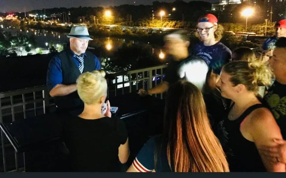 Mike DiDomenico performing strolling close-up magic at an upscale rooftop corporate event